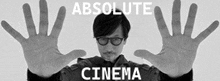 a black and white photo of a man with his hands outstretched and the words absolute cinema written above him