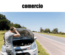 a man looking under the hood of a car with the word comercio written above him