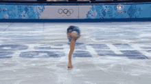 a female figure skater is doing a trick in front of a sign that says ' nbc ' on it