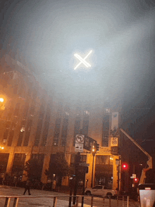 an x is lit up in the sky above a street sign