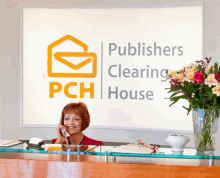 a woman talking on a phone in front of a pch clearing house sign