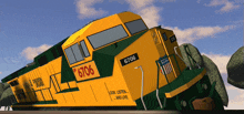 a yellow and green train with the number 6706 on it