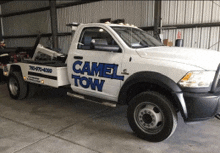 a white tow truck with camel tow written on the side