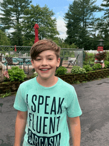 a young boy wearing a t-shirt that says " i speak fluent sarcasm "