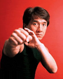 a man in a black tank top is making a fist in front of a red background