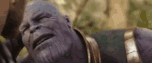 thanos from avengers infinity war is laying down with his eyes closed and a beard .