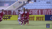 a group of soccer players are celebrating a goal in front of a banner that says " força jovei "