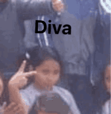 a girl is giving the middle finger in front of a crowd and the word diva is on the bottom of the picture .