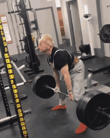 a man is lifting a barbell in a gym with a barbell rack that says ' a ' on it