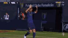 a soccer player giving a high five in front of a ventilation sign