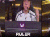 a person is sitting in front of a computer with a ruler logo on the screen .