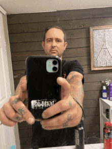 a man taking a picture of himself with a phone case that says rawheart