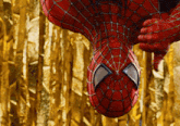 a close up of a spider man 's face with a gold background