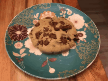 a cookie on a blue plate with a floral design