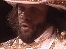 a man with a beard wearing a cowboy hat and a bow tie with a w on his chest