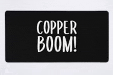 a black mat with white writing that says copper boom