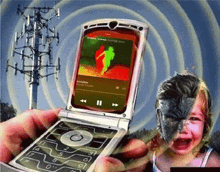 a person is holding a flip phone with a picture of a man on the screen