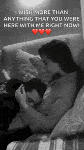 a man and a woman are sitting on a couch hugging and kissing .