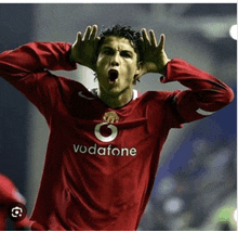 a soccer player wearing a red vodafone jersey screams