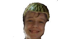 a young boy with a watermelon on his head smiles for the camera