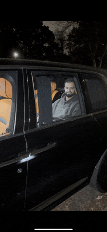 a man sitting in the back seat of a black car