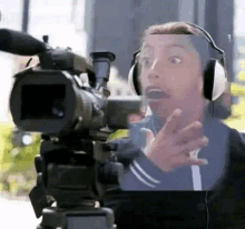 a man wearing headphones is looking at a camera .