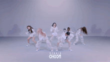 a group of women are dancing in front of a studio choom sign