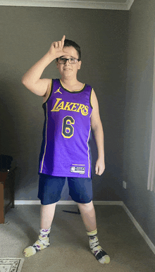 a young boy wearing a purple lakers jersey with the number 6 on it