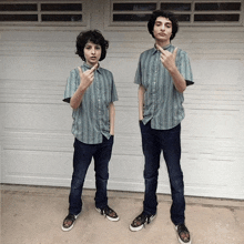 two boys standing next to each other in front of a garage door