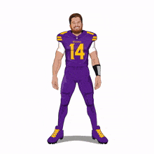 a man in a purple vikings jersey is pointing at something