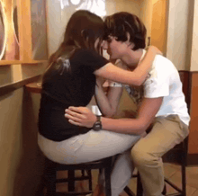 a man and a woman are kissing at a table