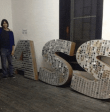 a man is standing next to a large letter a and s