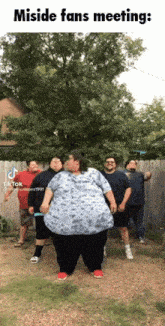 a group of men are standing in front of a fence and a woman is standing in front of them with the caption misside fans meeting