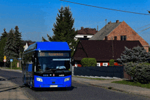 a blue bus with the number 196 on the front drives down a street