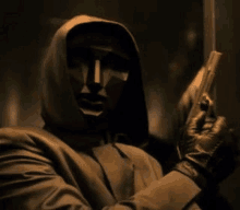 a man with a mask on his face is holding a gun .