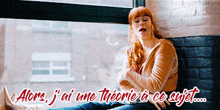 a woman sitting in front of a window with the words alone j ai une theorie a ce sujet written below her