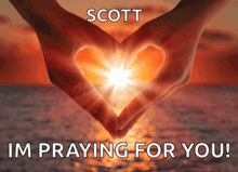 a person making a heart shape with their hands with the words scott im praying for you on the bottom