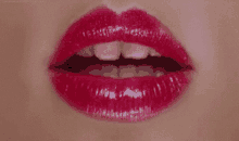 a close up of a woman 's mouth with red lips and white teeth .