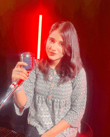 a woman holding a microphone in front of a red background