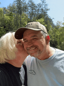 a woman kisses a man on the cheek who is wearing a t-shirt that says valley brook brewing company