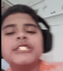 a young boy is wearing headphones and eating a piece of food .