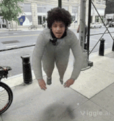 a man is flying through the air on a sidewalk with a bicycle in the background and the word vigle at the bottom