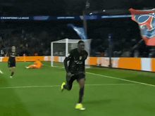a man running on a soccer field with champions league banners behind him