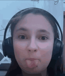 a woman wearing headphones is making a funny face .