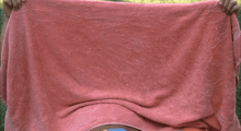 a man is wrapped in a pink towel with his eyes closed