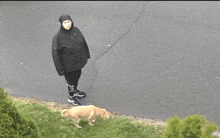 a person wearing a mask is walking a dog