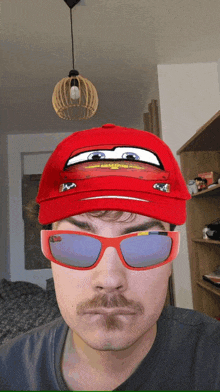 a man wearing a red hat and sunglasses has a lightning mcqueen face on his face