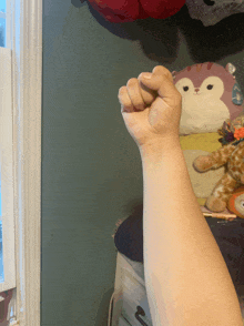 a fist is raised in front of a stuffed animal pillow