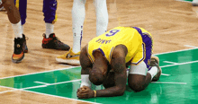 a basketball player with the number 9 on his jersey kneeling on the court