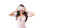 a woman covering her eyes with two donuts in her hands